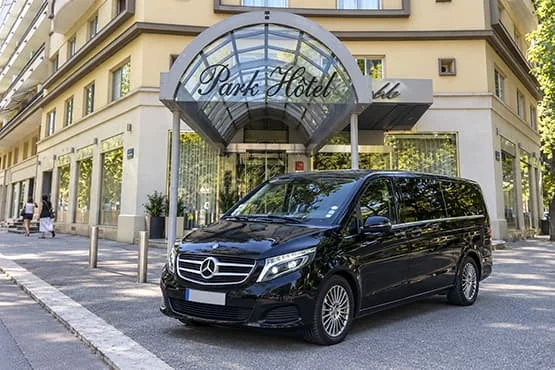 Van Mercedes noir devant l’entrée du Park Hôtel.